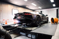 Matte black Lamborghini Aventador with glowing exhausts strapped on Dynocom AWD 8000 dynamometer at Dyno Dampz