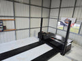 Dynocom 2WD 8000 Series chassis dynamometer installed in metal shop building with Dynocom Racing banner
