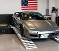 Silver Honda NSX on Dynocom 6000 Series dyno in clean performance shop with American flag