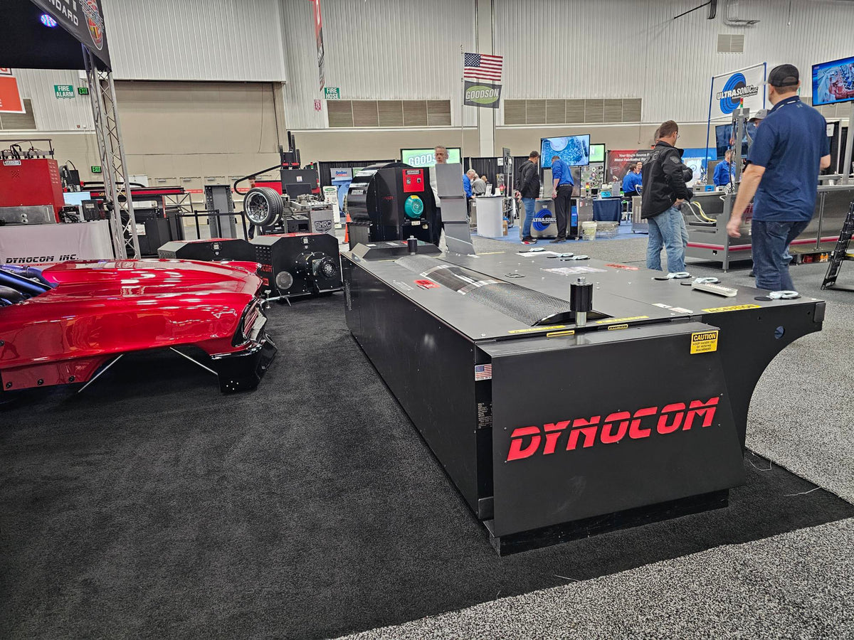 Dynocom 8000 Series dynamometer on display at trade show with red drag car alongside
