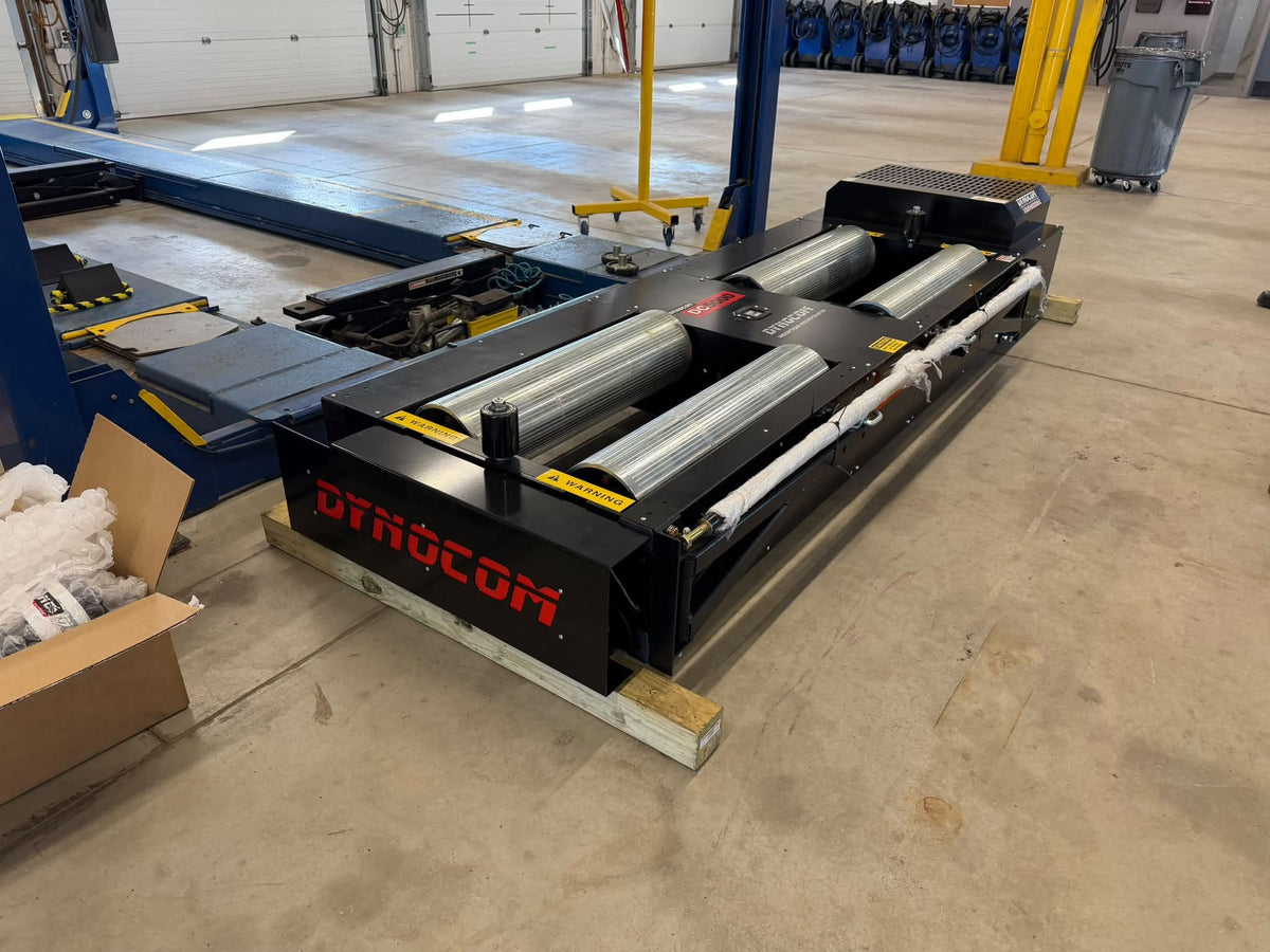Brand new Dynocom 5000 Series dynamometer on pallet in shop with lift bays
