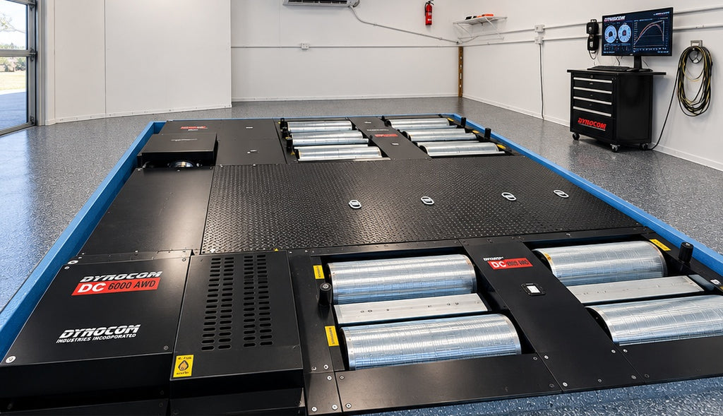 Dynocom DC 6000 AWD chassis dynamometer pit-mount installation in clean white dyno room with Quantum software monitor